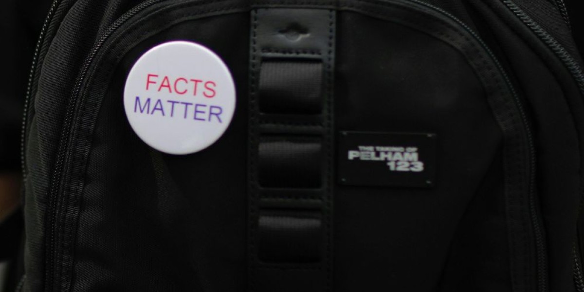 A button saying facts matter on a backpack.